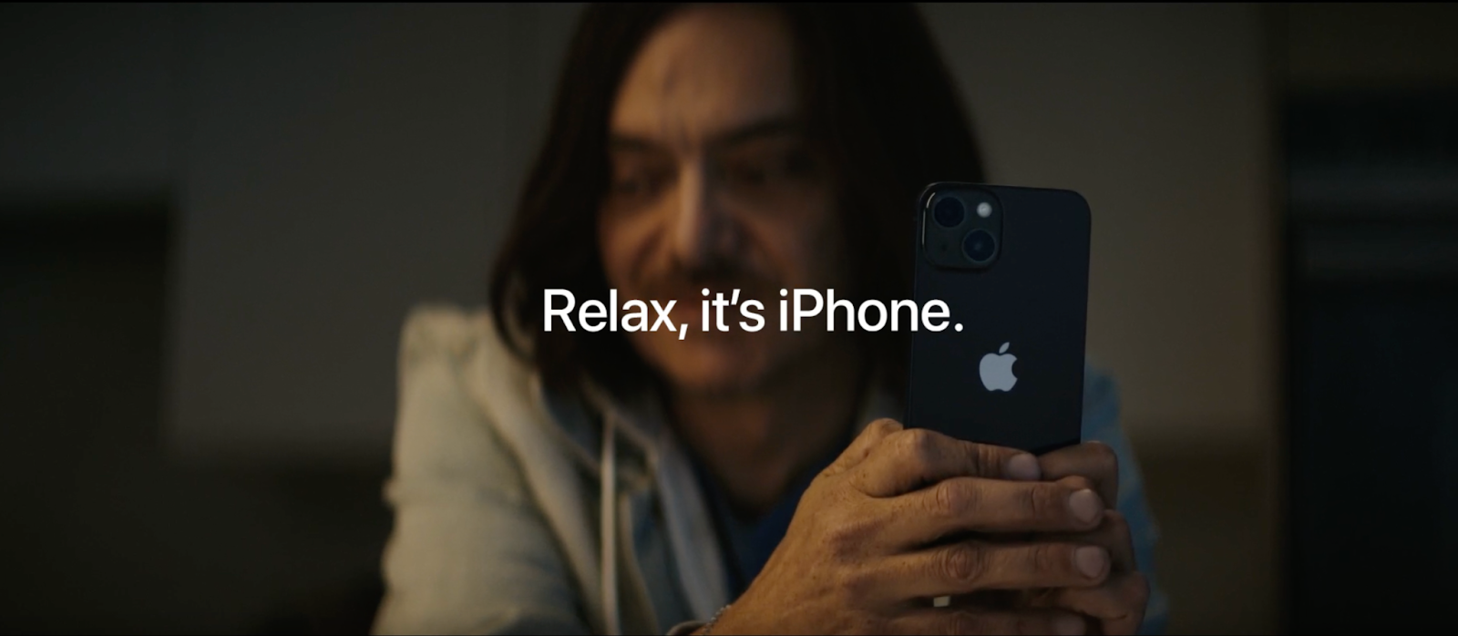 Apple iPhone ad showing a person holding an iPhone with the text “Relax, it’s iPhone.”